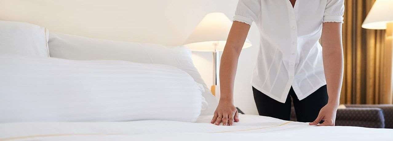 Hotel staff making a bed