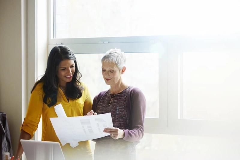Two people discussing business documents