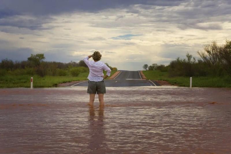 Person stood in flood water looking an the damage around them