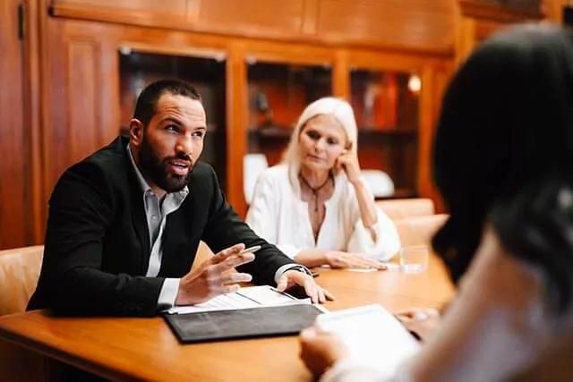 Two women and a man are engaged in a discussion or a business meeting.